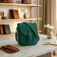 Green bag on a marble surface with a wooden shelf in the background