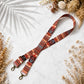 Patterned strap with hooks on a light surface with dried flowers