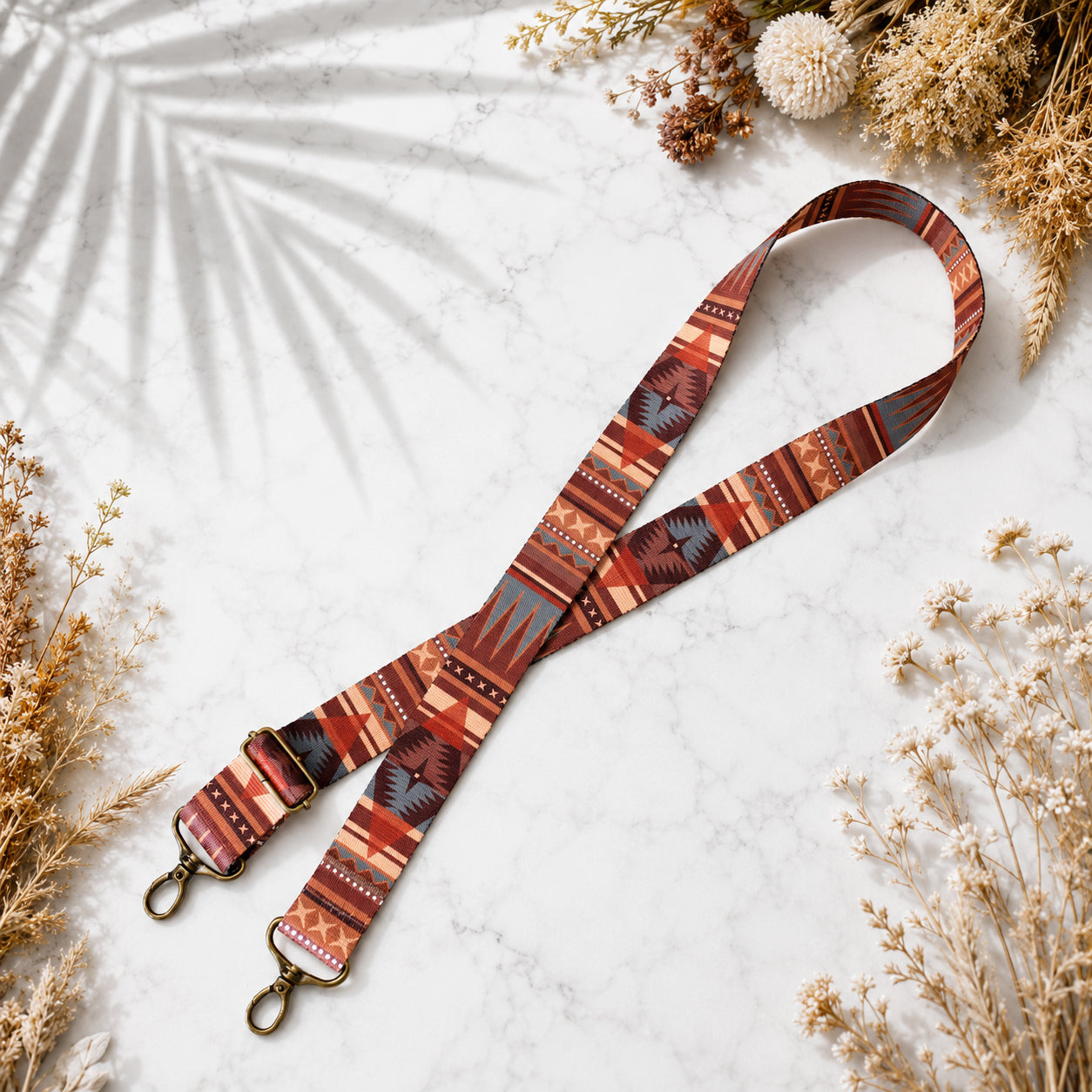 Patterned strap with hooks on a light surface with dried flowers