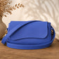 Blue handbag on a wooden surface with decorative elements