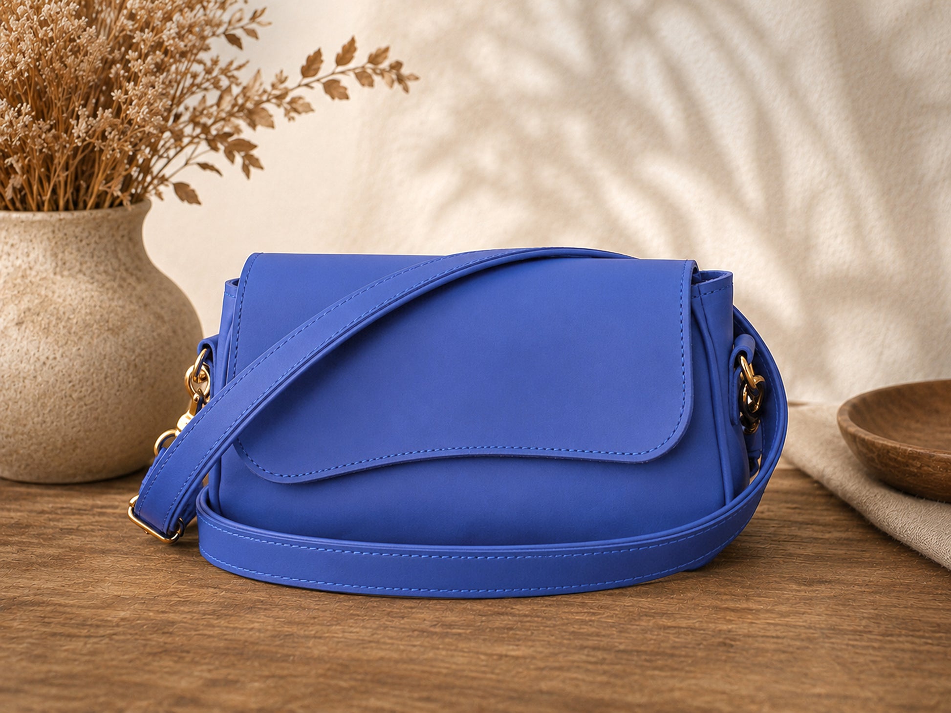 Blue handbag on a wooden surface with decorative elements