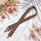 Decorative strap with floral pattern on a light surface with flowers and leaves.