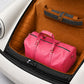 Pink duffel bag in the trunk of a car with a brown interior.