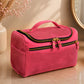 Pink cosmetic bag on a bathroom counter with decorative elements.