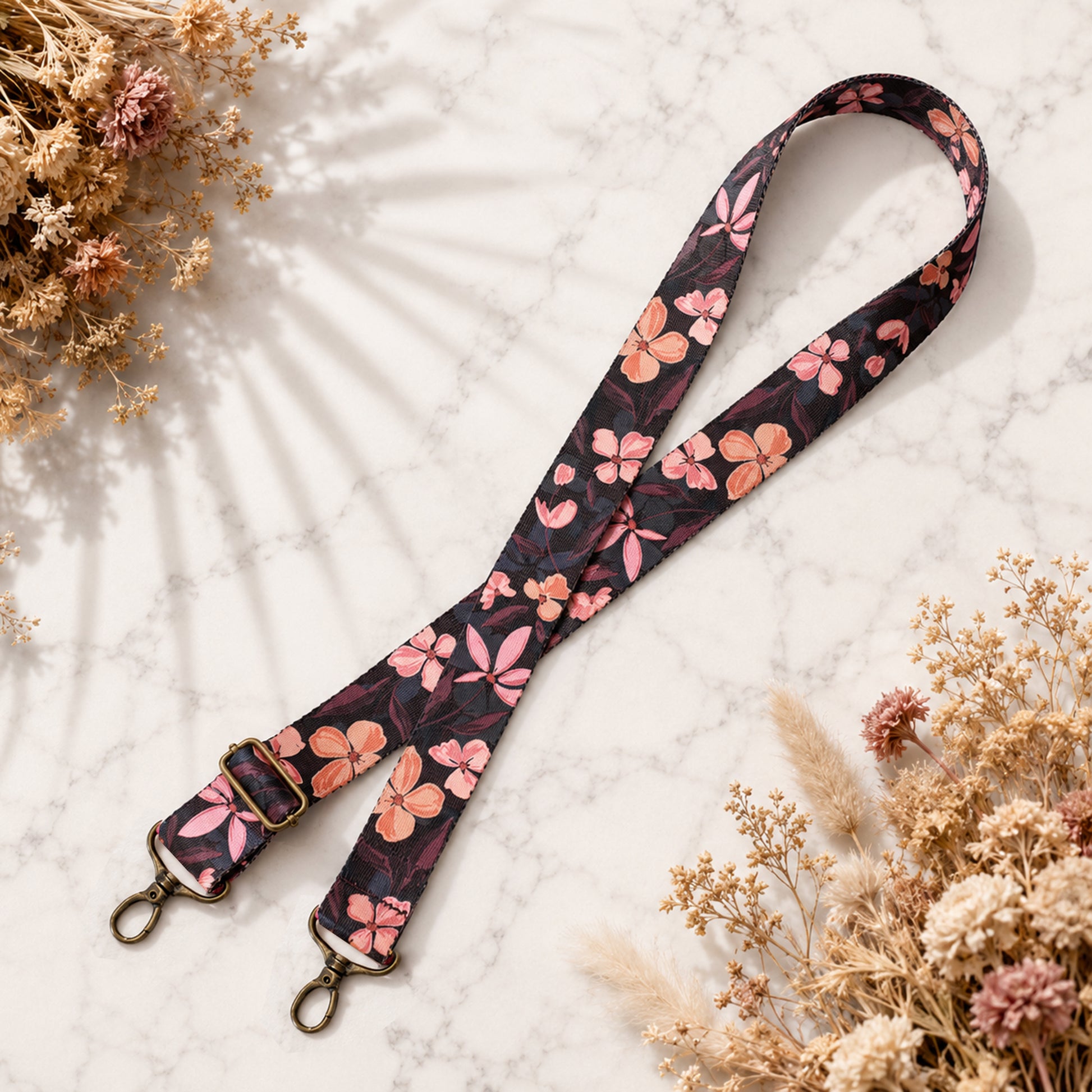 Floral patterned lanyard on a textured surface with dried flowers