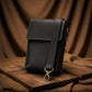 Black leather pouch with a gold hook on a wooden surface with brown fabric background