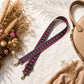 Dog leash with skull pattern on a light surface with flowers and a handbag.
