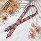 Floral patterned lanyard on a marble surface with dried flowers
