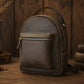Brown leather backpack on a wooden surface with a warm, rustic background