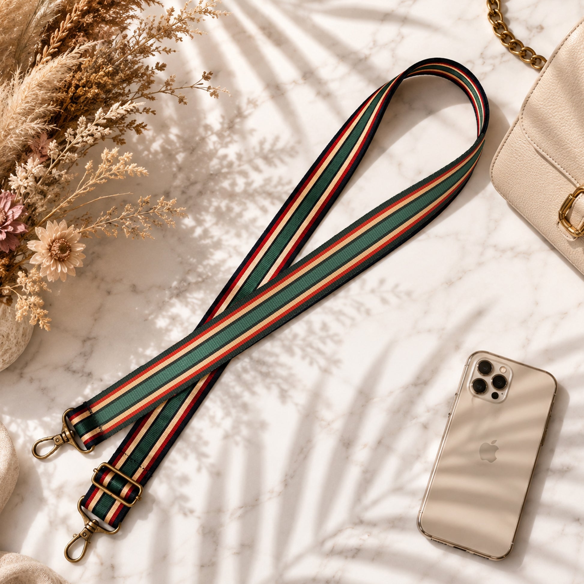 Striped bag strap with phone and beige handbag on a soft surface