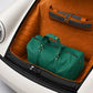Green duffel bag in the trunk of a car with a brown interior.