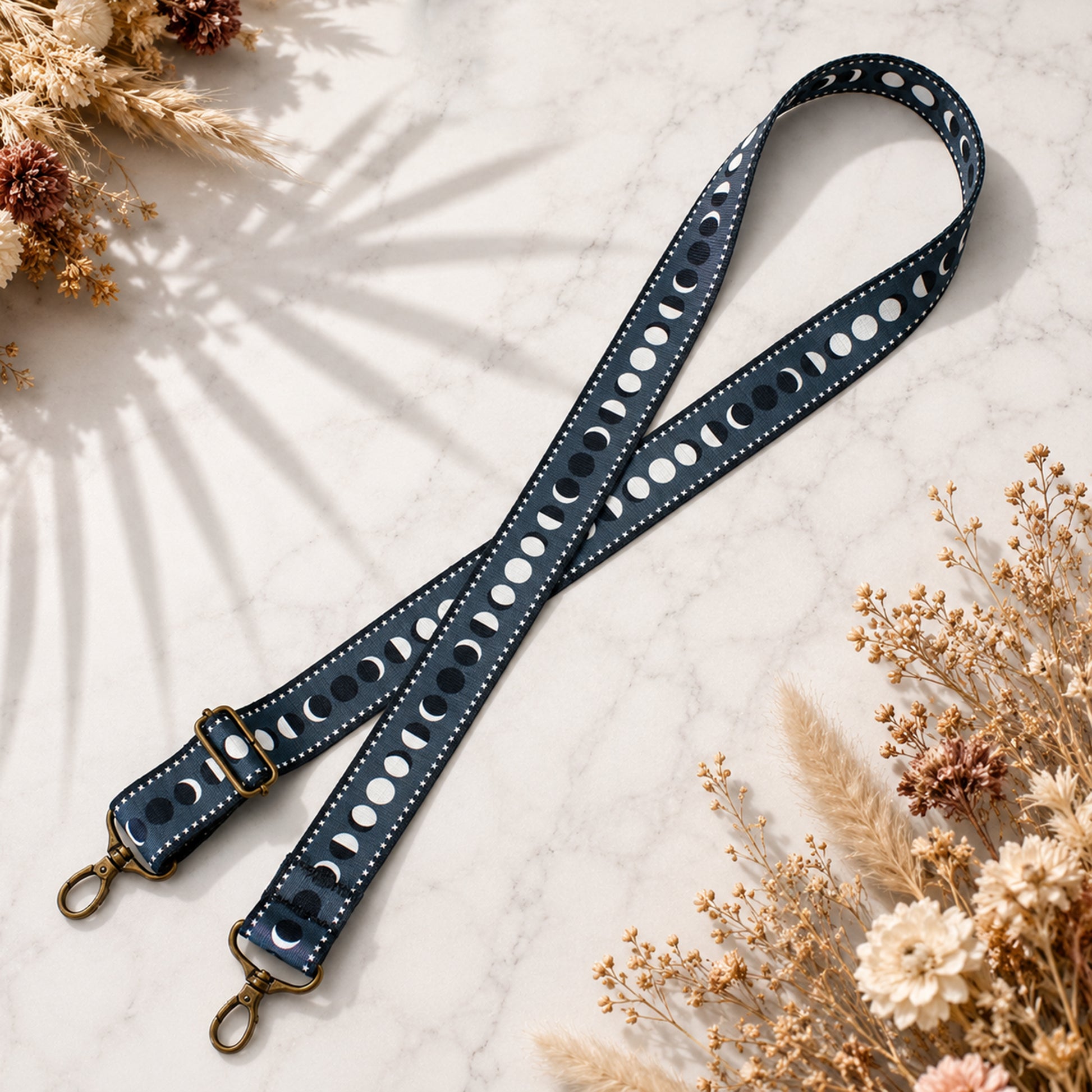 Blue leather strap with cut-out design on a light surface with dried flowers.