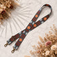 Decorative strap with floral pattern on a marble surface with dried flowers.