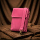 Pink crossbody bag on a wooden surface with a brown fabric background