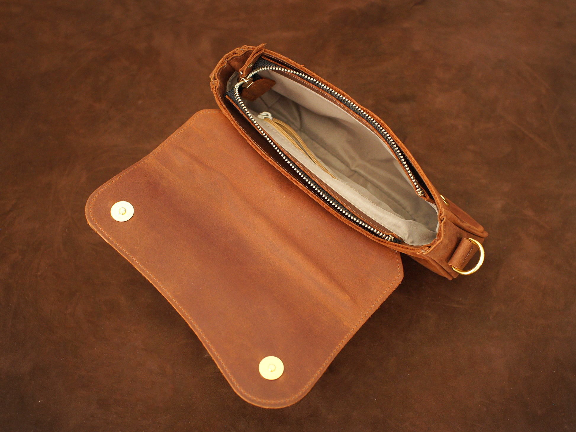 Interior of leather crossbody pouch, organized compartments for daily essentials