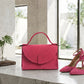 Pink handbag and high heels on a marble surface with a blurred outdoor background