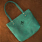 Leather tote bag collection with personalized engravings, lifestyle flat lay