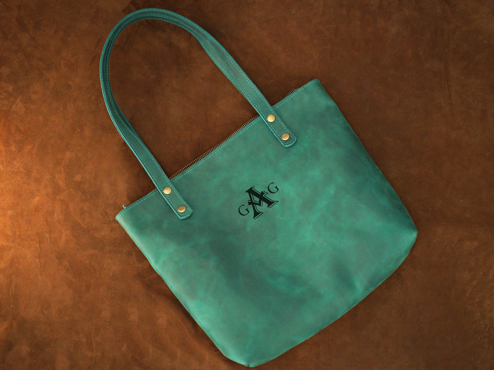 Leather tote bag collection with personalized engravings, lifestyle flat lay