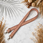 Decorative strap with floral patterns on a marble surface with dried flowers.