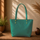 Teal handbag on a wooden surface with plants and books in the background