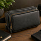Black leather crossbody bag on a wooden surface with a plant, book, and candle in the background.