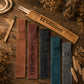 Five personalized leather pencil cases in brown, reddish-brown, black, teal, and gray, laid out on a rustic wooden surface with dried flowers and rope props. The cases are engraved with names including William, James, Thompson, Sanders, and TR.