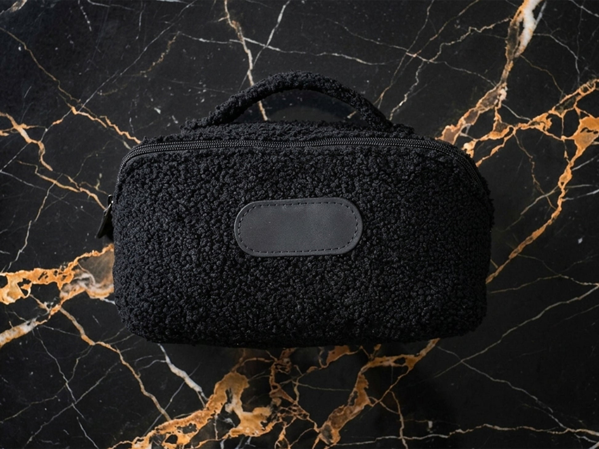 Black textured pouch on a marble surface