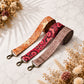 Three floral patterned straps on a light background with dried flowers.