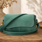 Green handbag on a wooden surface with a blurred background