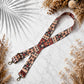 Patterned strap on a marble surface with dried plants