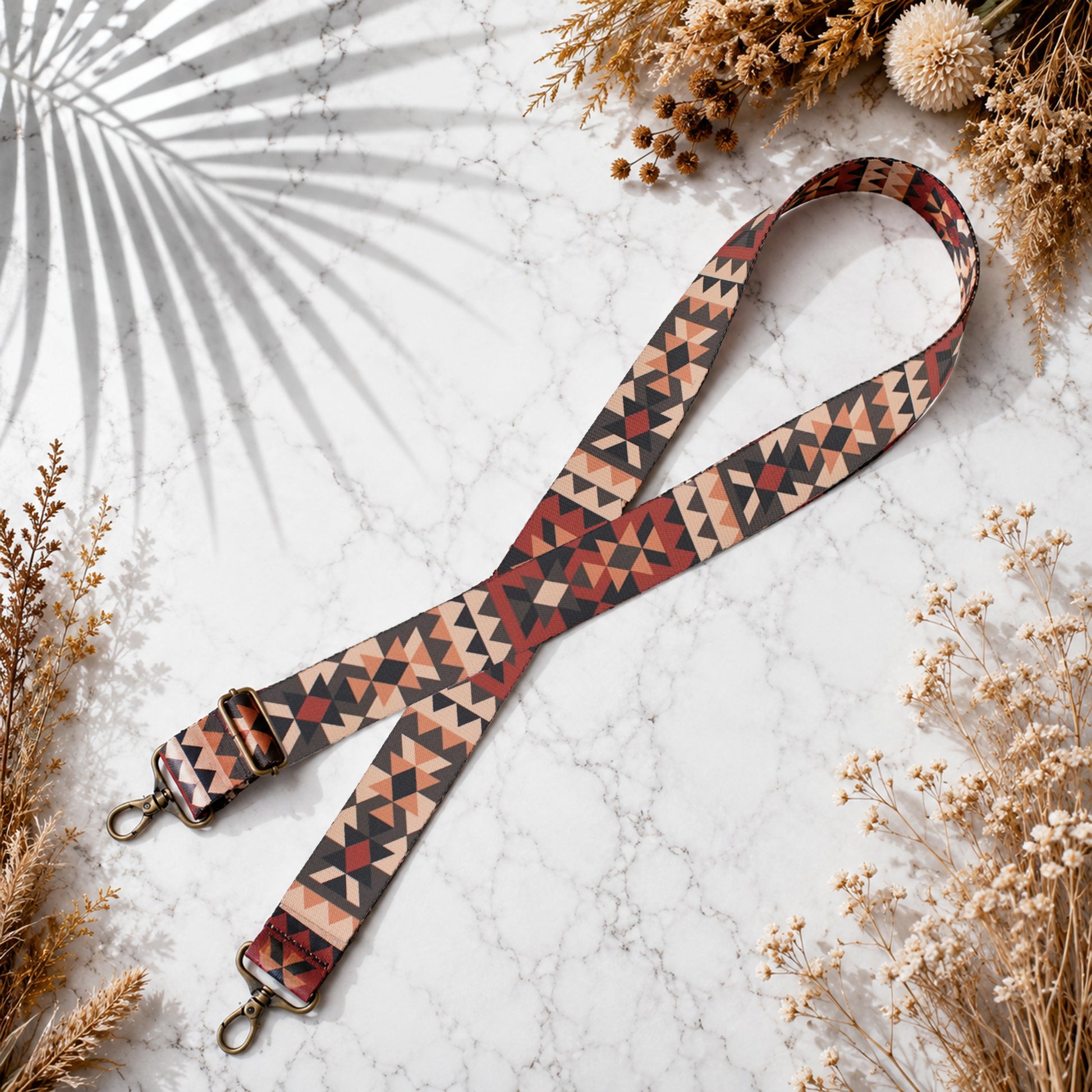 Patterned strap on a marble surface with dried plants