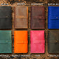 Collection of leather wallets in various colors on a wooden surface