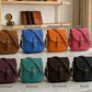 Collection of colorful leather bags on a marble surface with labeled colors.