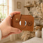 Leather bifold wallet with AirTag slot detail, durable brass hardware