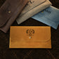 The Envelope leather clutch in use outdoors, warm earthy tones