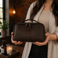 Person carrying personalized leather dopp kit, lifestyle editorial photo