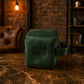 Green suede pouch with 'Michelle' embroidery on a marble surface with a brick wall background
