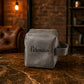 Gray suede bag with 'Veronica' branding on a marble surface with a rustic background.