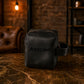 Black leather bag with 'Adeline' branding on a textured surface with a warm-toned background.