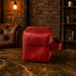 Red leather bag with 'LAUREN' monogram on a marble surface with a rustic background