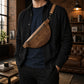 Leather crossbody bag in use outdoors, warm earthy tones