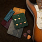 Leather guitar pick holder collection with personalized engravings, flat lay