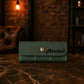 Green leather wallet with 'Marshall' branding on a marble surface with a dark background.