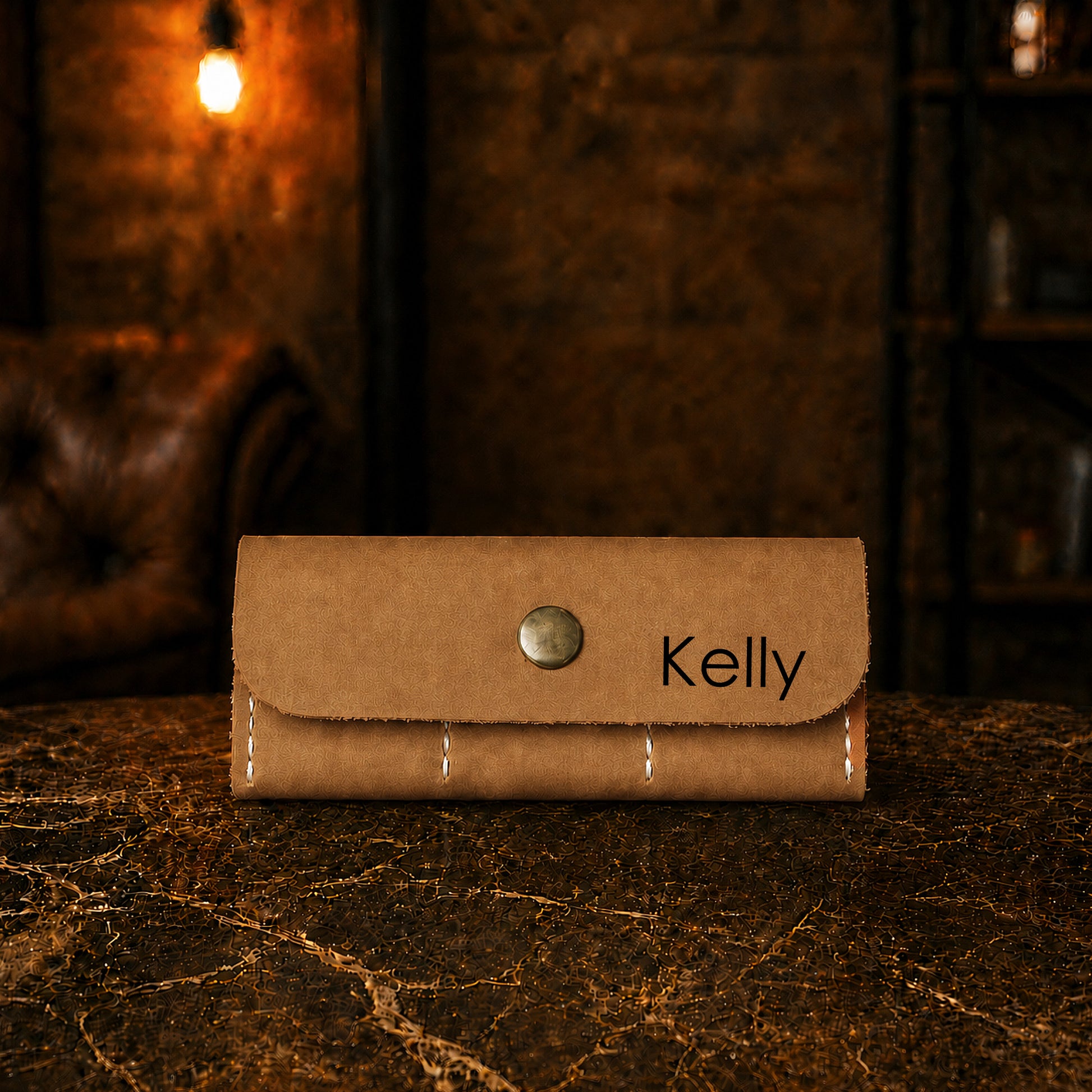 Brown leather wallet with 'Kelly' engraving on a dark surface