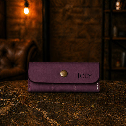 Purple wallet with 'JOEY' branding on a dark surface with a warm, blurred background
