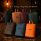 Collection of personalized leather bags in various colors with names engraved on them, set against a dark background.