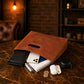 Brown leather pouch with monogrammed name, containing various items on a wooden surface.