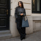 Leather handbags with custom engravings displayed on wooden surface
