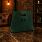 Green bag with 'KP' logo on a marble surface with a warm-toned background