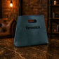 Blue bag with 'Veronica' printed on it on a marble surface with a dark background